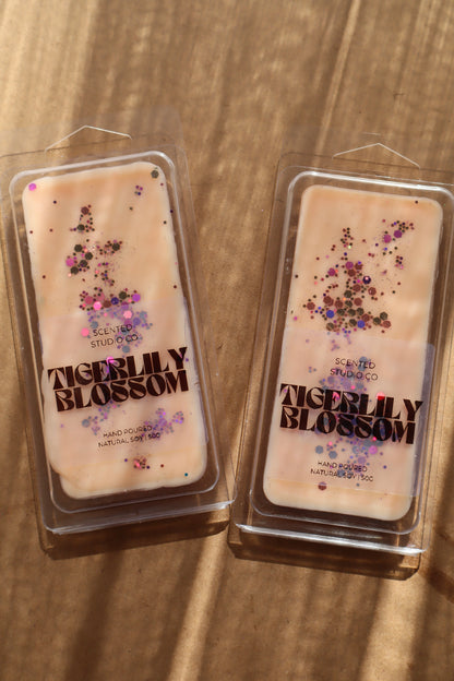 Two packages of Tigerlily Blossom wax melts on a wooden surface